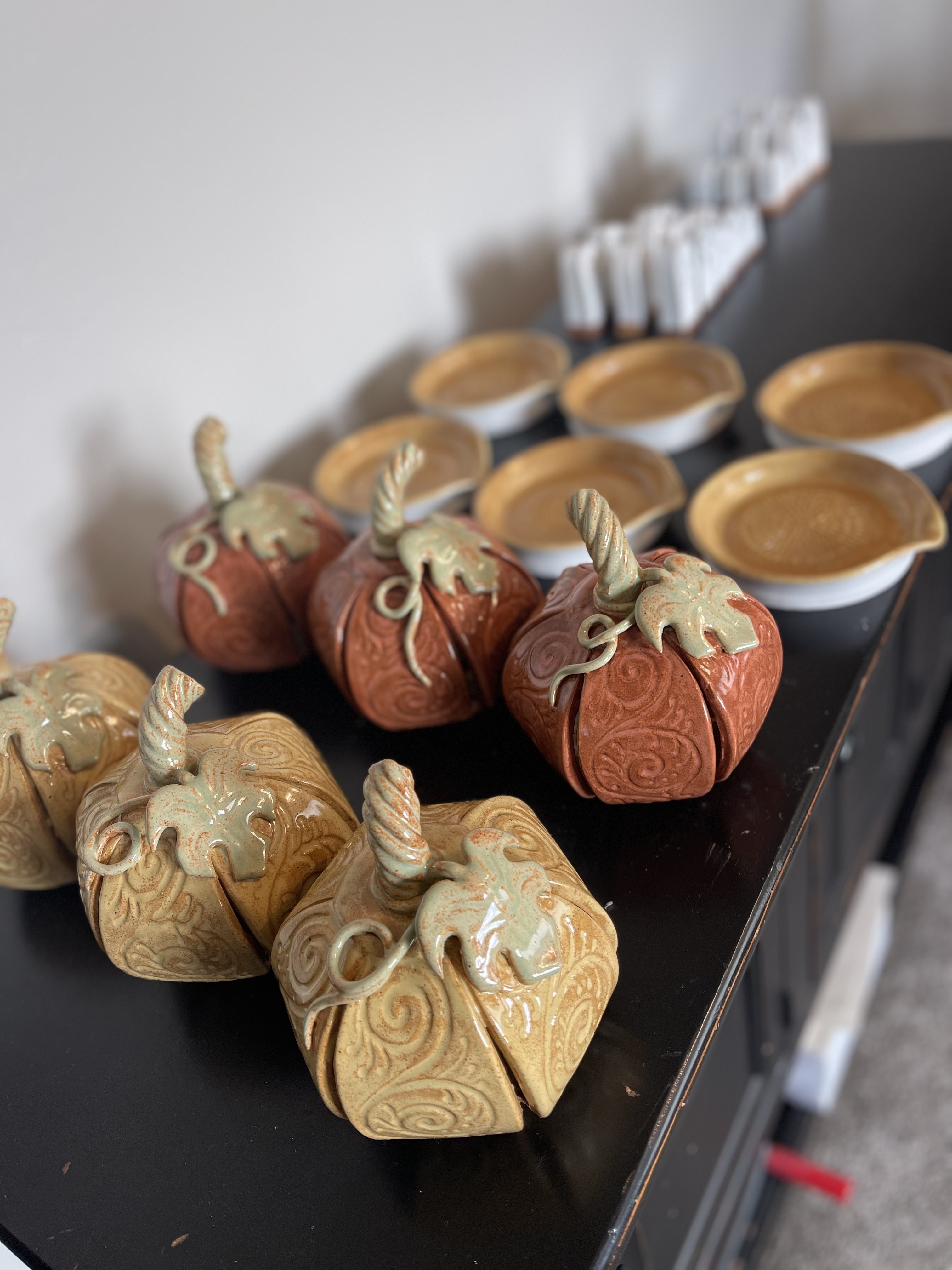 Collection of handmade orange and yellow ceramic pumpkins