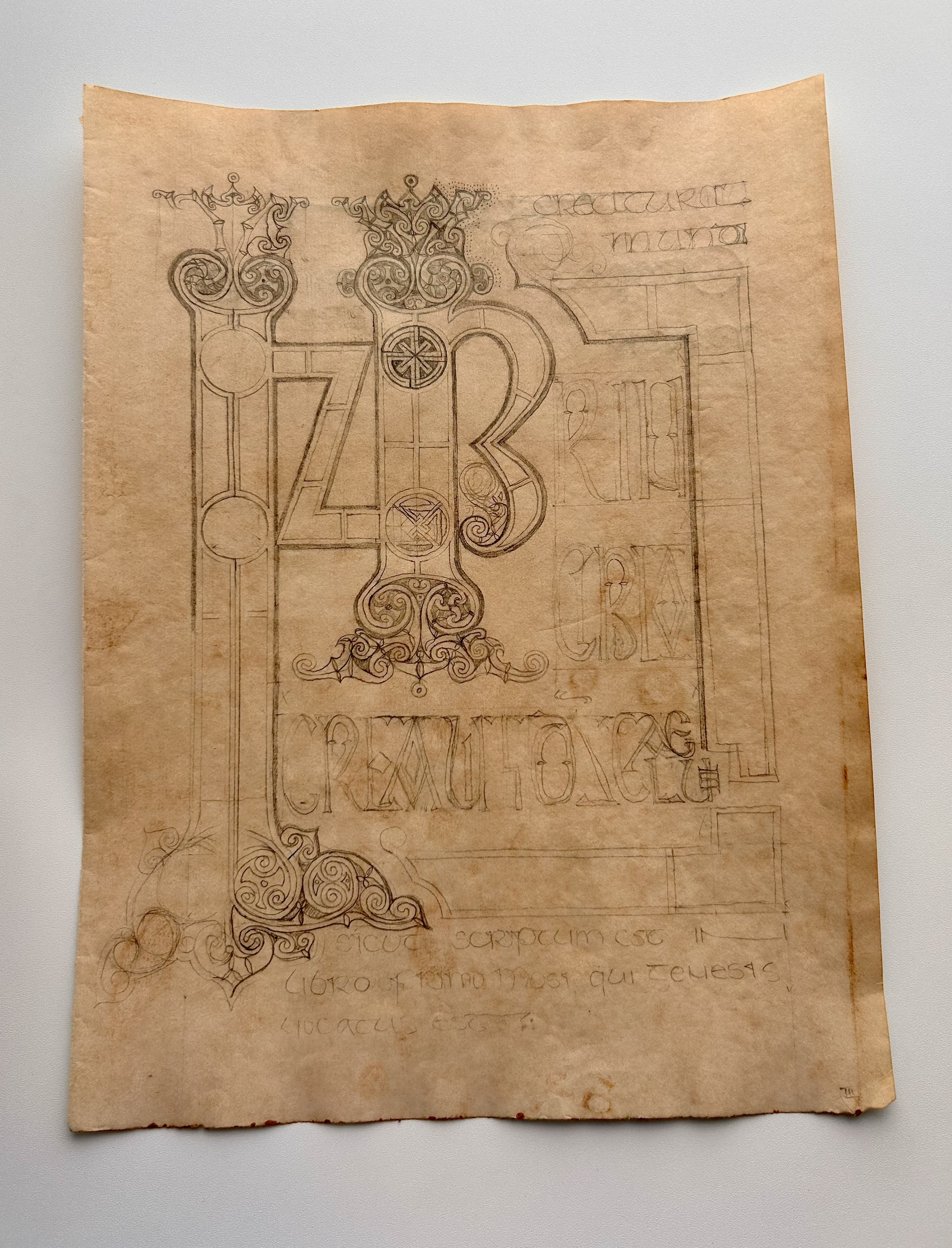 Aged manuscript page with large decorative letterforms and ornamental sketches