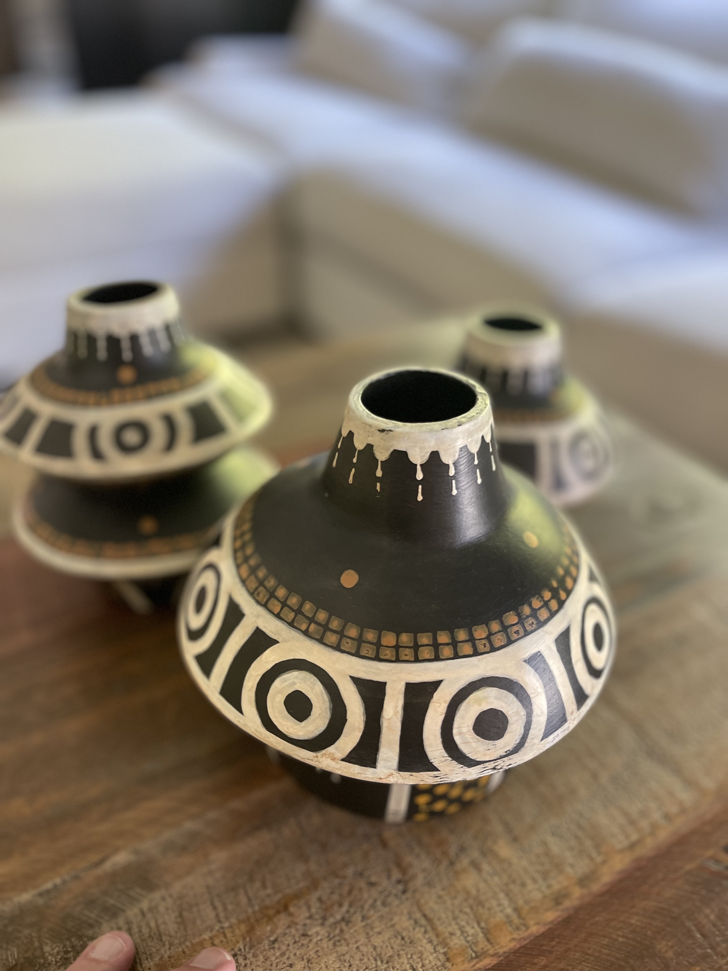 Group of three ornamented ceramic jugs arranged on a wooden surface