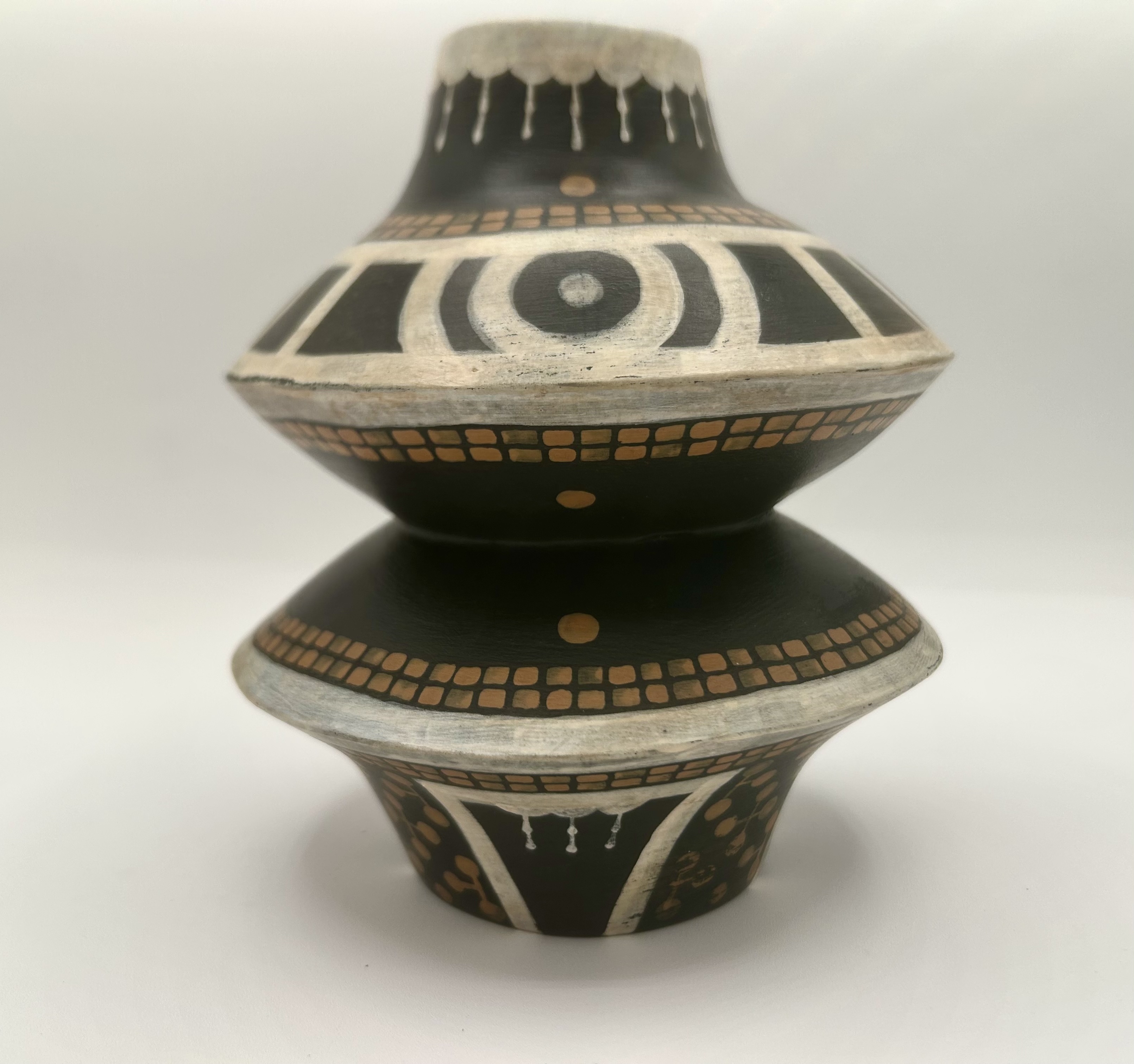 Tiered black ceramic jug with bold white bands and circular geometric motifs